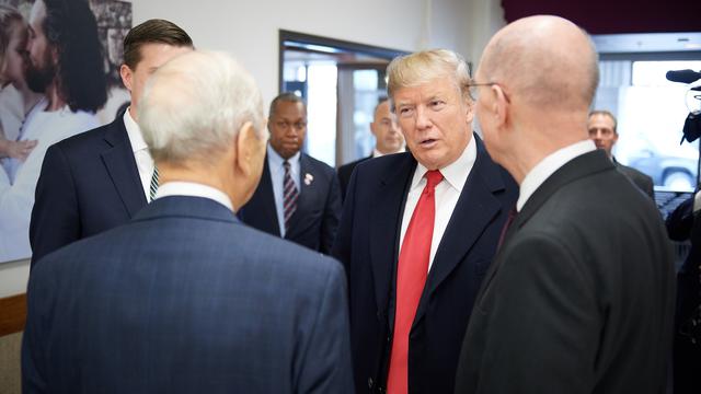 Yhdysvaltain presidentti Donald J. Trump keskustelemassa ensimmäisen presidenttikunnan jäsenen, presidentti Henry B. Eyringin kanssa (oikealla) sekä kahdentoista apostolin koorumin jäsenen, presidentti Russell M. Nelsonin kanssa (vasemmalla) huoltotyöaukiolla Salt Lake Cityssä 4. joulukuuta 2017.