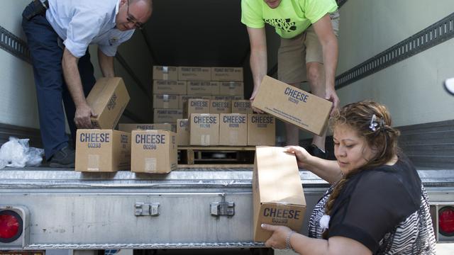 Salt Lake Cityssä sijaitsevan Hildegarde’s Pantry -ruokapankin johtaja Lydia Herrera auttaa huoltotyöpalveluista saapuneiden juustolaatikkojen purkamisessa. Episkopaalisen kirkon jäsenet tekivät vapaaehtoistyötä huoltotyöaukiolla pakaten juustoa ja muita tuotteita ruokapankkia varten.