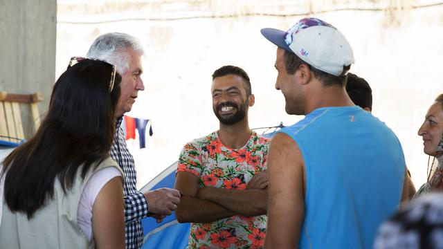 President Dieter F. Uchtdorf of the First Presidency of The Church of Jesus Christ of Latter-day Saints visits with a family at the Piraeus refugee camp in Anthens, Greece, July 22, 2016.