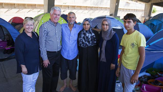 President Dieter F. Uchtdorf of the First Presidency of The Church of Jesus Christ of Latter-day Saints, with daughter Antje Evans (left), visits with a family at the Piraeus refugee camp in Athens, Greece, July 22, 2016.